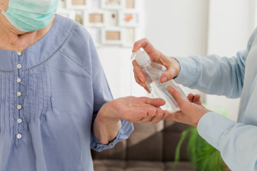 Two care workers sanitising their hands